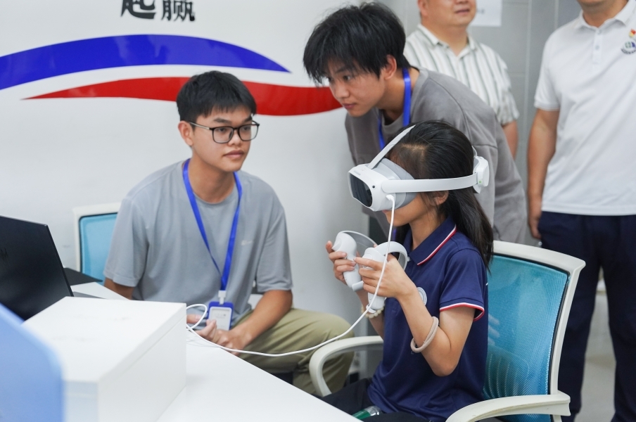 beat365中文唯一官网信息工程学院学生正在指导研学团成员体验VR游戏。